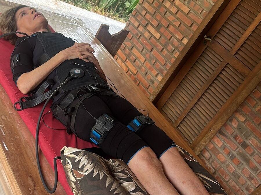 Mulher deitada com aparelhos de fisioterapia em seu corpo