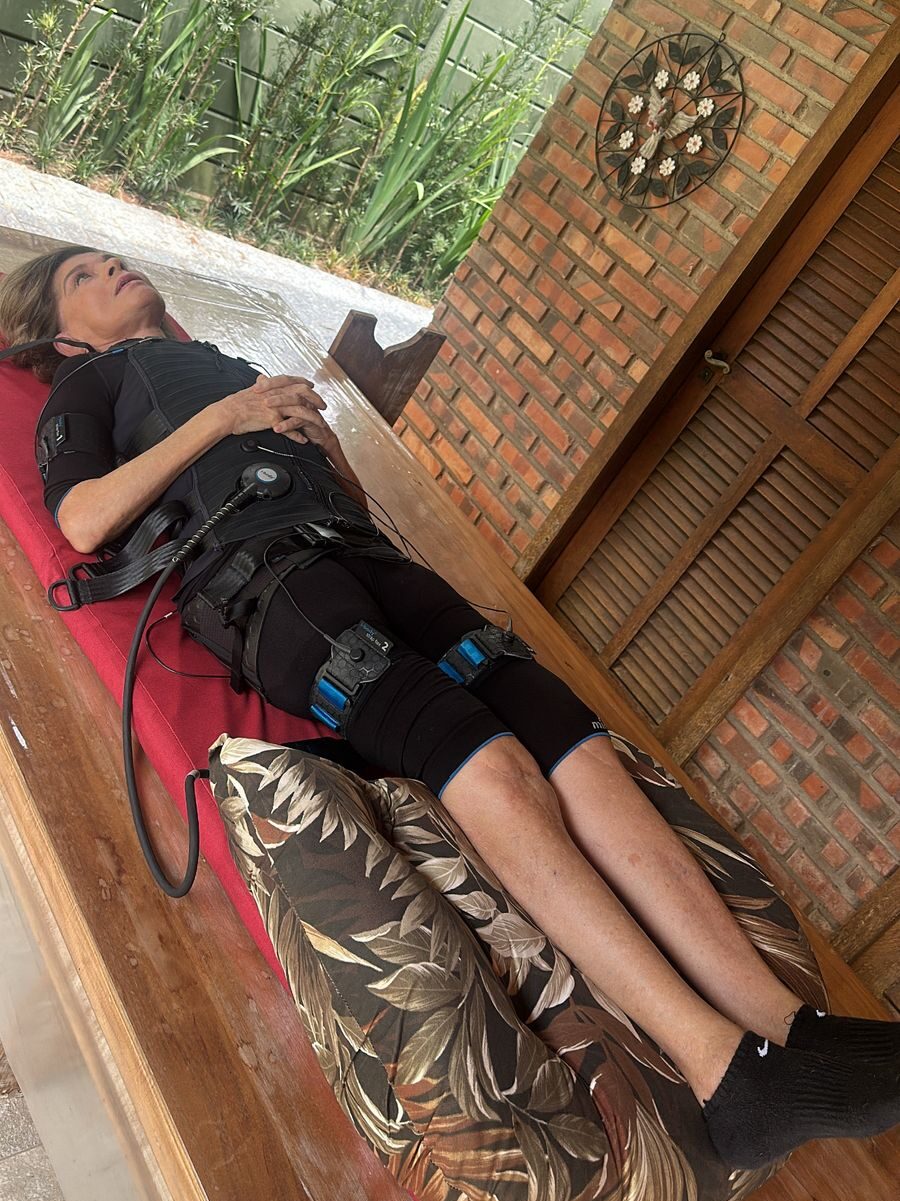 Mulher deitada com aparelhos de fisioterapia em seu corpo